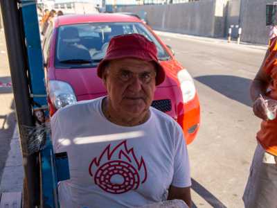 Seduto su una sedia, dietro il �bancone�, c�� lui: occhi verdi, maglia bianca e cappellino rosso